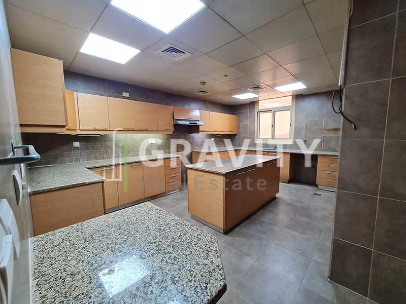 Massive-kitchen-with-wooden-cabinets-exhaust-marbled-tabletops-and-table-in-the-middle-of-the-kitchen-Golf-Gardens