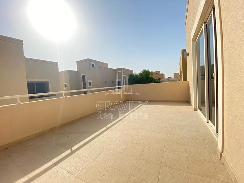 Balcony-with-a-huge-layout-brown-colored-squared-tiles-with-white-metal-railings-and-other-villas-surrounding-the-view-in-Al-Raha-gardens