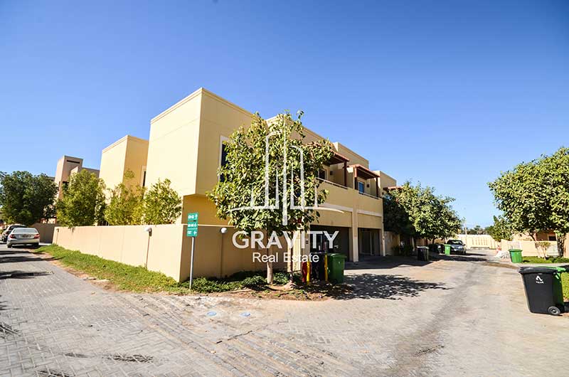 Corner-side-of-the-Townhouse-in-Al-Raha-Gardens-with-a-tree-in-front-of-it