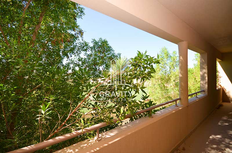 Elongated-balcony-having-cream-colored-walls-and-railings-with-a-tree-having-in-the-balconys-view-in-Al-Raha-Gardens