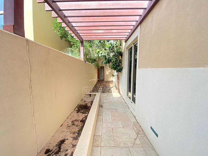 Elongated-pathway-with-stoned-tiles-with-shade-leading-to-the-back--of-the-villa-in-Al-Raha-Garden