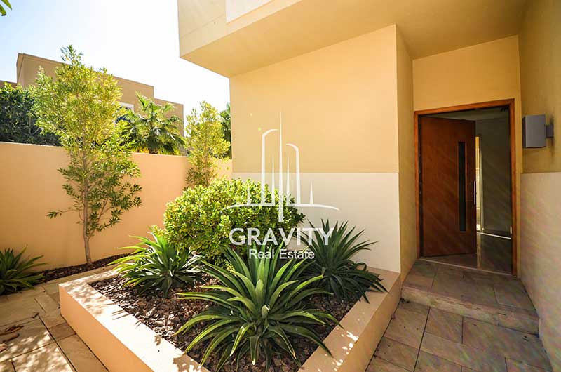 Entrance-to-the-4-bedroom-cream-colored-townhouse-in-Al-Raha-Gardens-with-plants-on-the-side