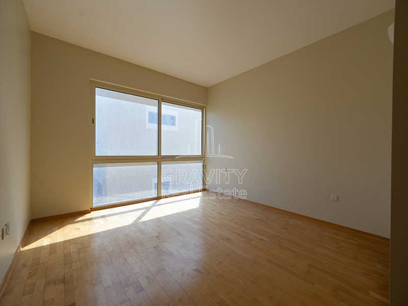 Room-in-Al-Raha-Gardens-having-wooden-floor-and-window-in-the-corner