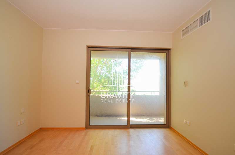 Room-from-a-townhouse-in-Abu-Dhabi-having-wooden-flooring-cream-colored-walls-and-an-opening-to-the-balcony