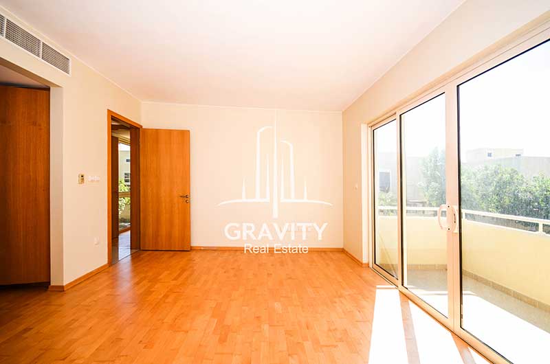 Spacious-bedroom-with-wooden-floorings-and-windowed-sliding-doors-opening-to-the-balcony-in-Al-Raha-Gardens