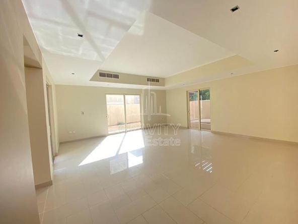 Spacious-living-room-in-Al-Raha-Garden-3-bedroom-Villa-having-white-tiles-cream-colored-walls-with-2-openings-having-windowed-sliding-door