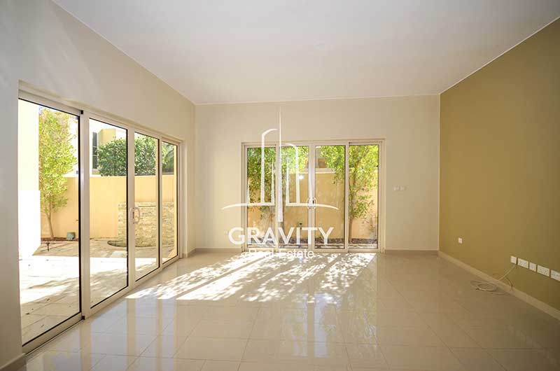 Spacious-living-room-with-windowed-doors-opening-to-the-backyard-in-a-Al-Raha-Gardens-Townhouse