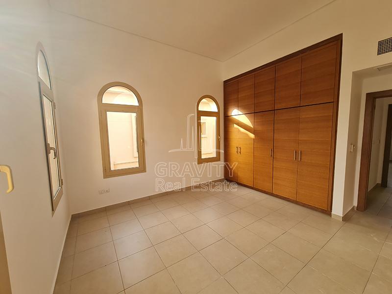 Square-shaped-bedroom-having-windows-and-built-in-wooden-wardrobes-in-Al-Raha-Golf-Gardens