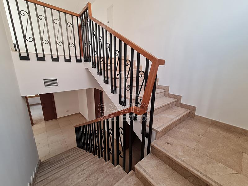 The-staircase-leading-from-the-ground-floor-to-the-first-floor-has-a-wooden-railing-and-marbled-steps-in-Al-Raha-Golf-Gardens