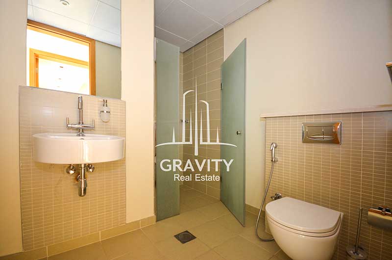 Toilet-in-Al-Raha-Garden-4-bedroom-Townhouse-for-sale-having-a-cubicle-shower-space-a-toilet- and-sink-with-mirror