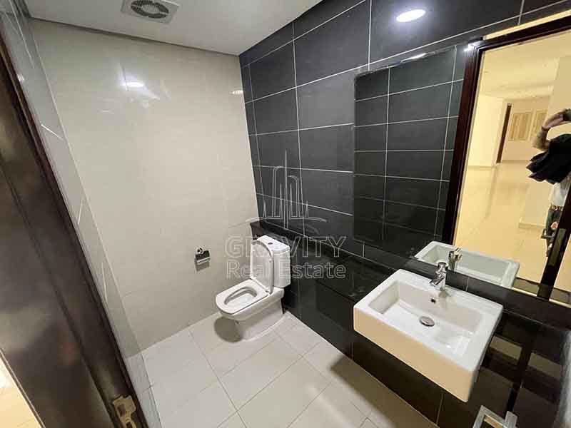 Toilet-with-balck-tiles-on-the-walls-in-MAG-5-apartment-for-sale-in-Al-reem-Island