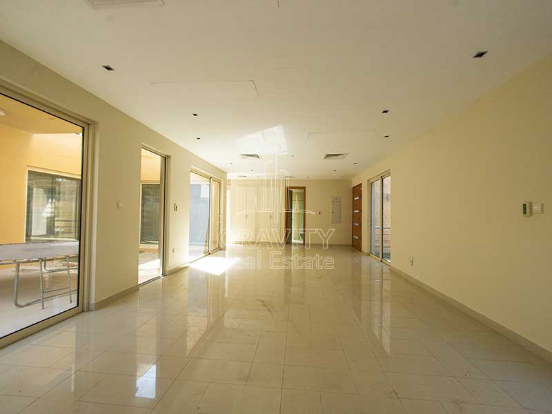 Vertically-vast-living-area-with-tiles-with-windows-on-either-side-in-the-villa-for-sale-in-Al-Raha-Garden