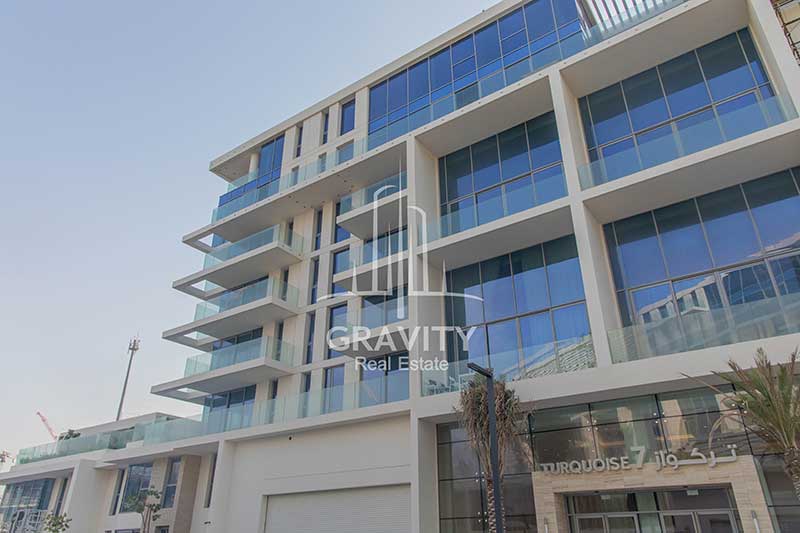 mamsha-saadiyat-island-bulding-from-outside-with-double-glazed-windows-and-trees-in-the-entrance