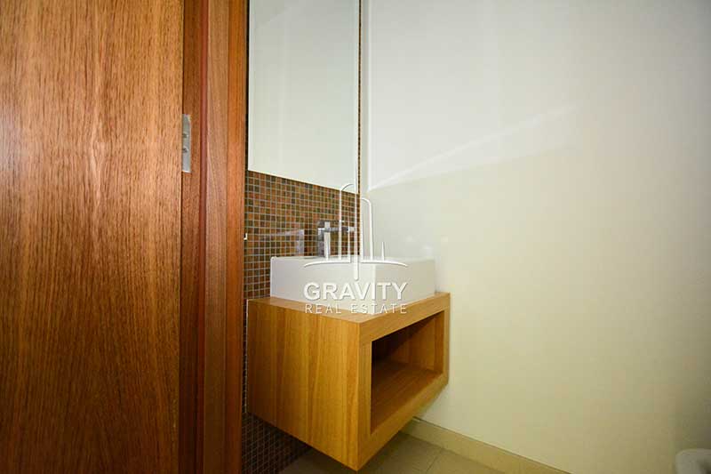 rectangular-wash-basin-right-below-a-mirror-where-the-walls-are-tiled-in-apartment-Al-Raha-beach