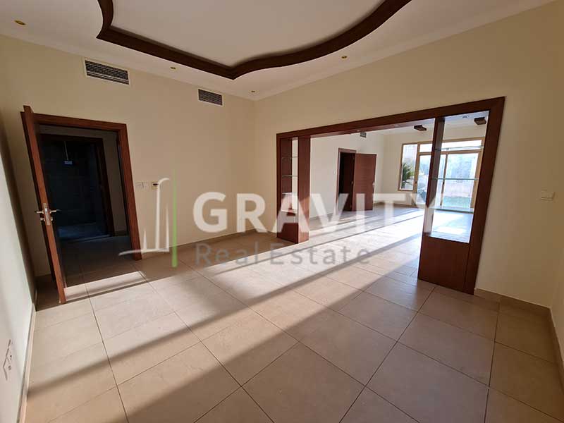 room-has-a-wooden-partition-with-shelves-and-a-door-opens-to-another-room-in-a-villa-for-sale-in-Al-Raha-Golf-Gardens