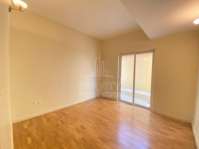 small-bedroom-in-an-al-raha-gardens-villa-with-cream-colored-walls-and-wooden-floorings-with-an-exit