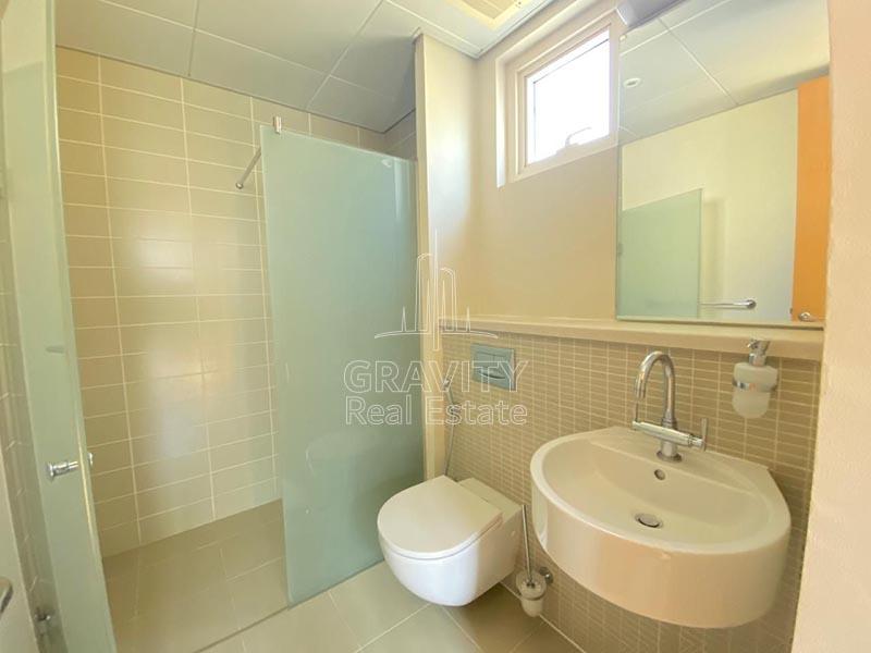 toilet-in-villa-havin-grey-colored-rectangular-shaped-tiles-walls-with-a-partition-separating-the-shower-head-and-the-toilet-wash-basin-and-mirror