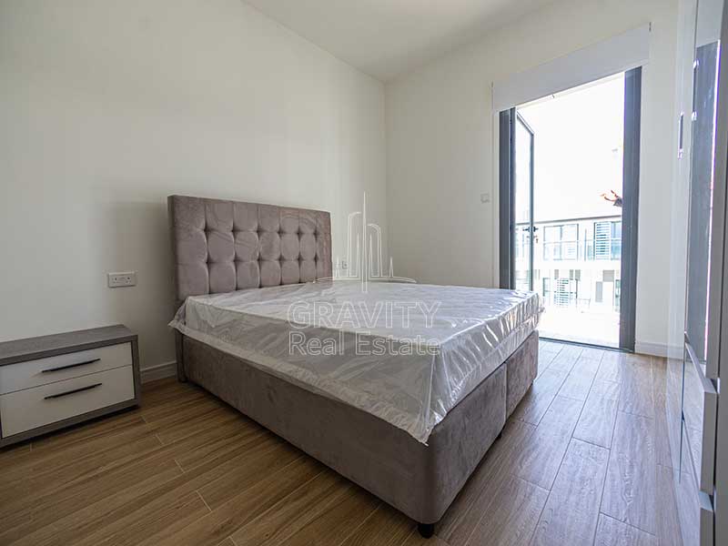 bedroom-with-large-bed-and-wooden-floors-in-apartment-in-al-raha-lofts