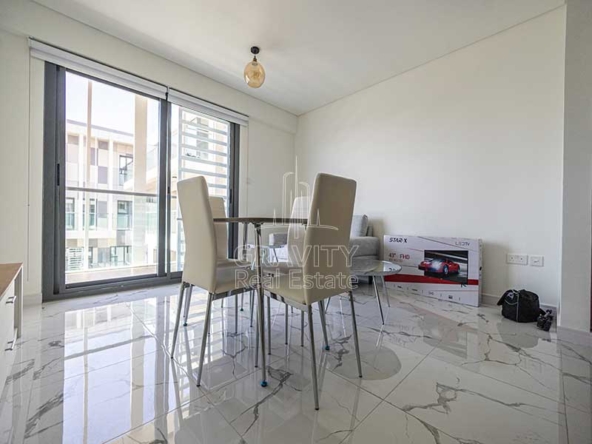 dining-area-with-tables-and-chairs-and-couch-in-al-raha-lofts-al-raha-beach