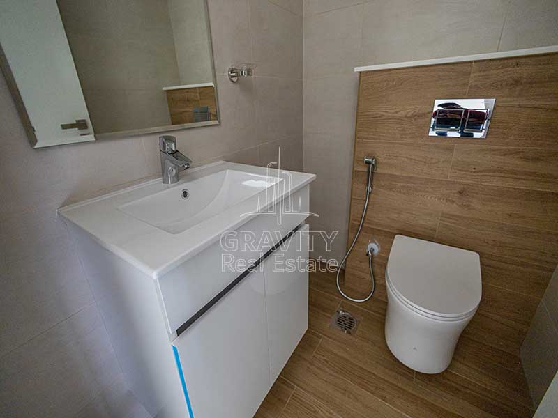 powder-room-with-wooden-floors-toilet-and-sink-in-stunning-2-bedroom-apartment-al-raha-lofts