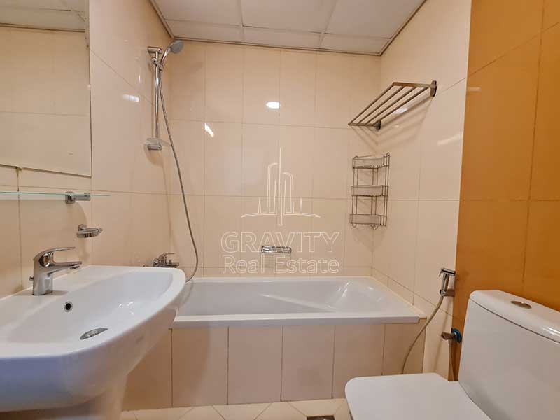 bathroom-with-cream-colored-walls-spacious-bathtub-toilet-and-sink-in-2-bedroom-townhouse-in-hydra-avenue-reem-island