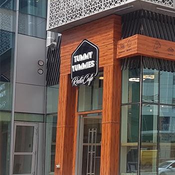 tummy-yummies-exterior-with-wooden-cladding-and-restuarants-logo-clearly-showing-on-two-sides