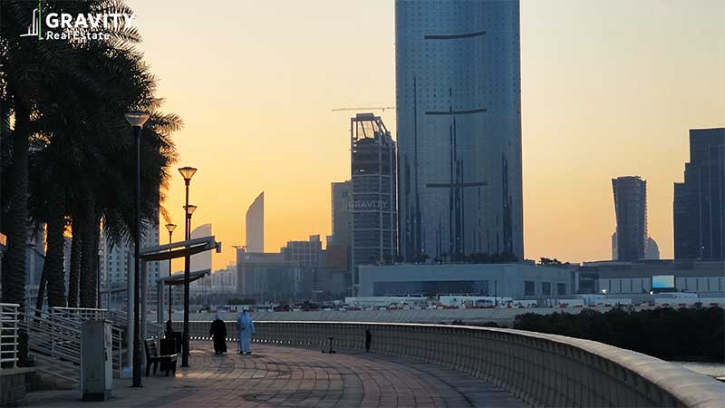 city-of-lights-promenade-with-old-arab-couple-walking-in-a-distance-during-sunset-with-the-leaf-tower-in-a-distance