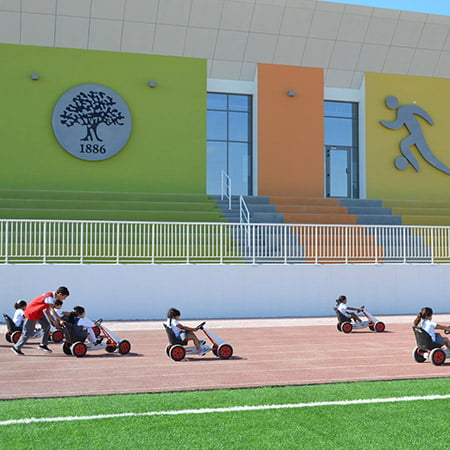 Sabis-school-running-track-with-children-playing-on-miniature-vehicles