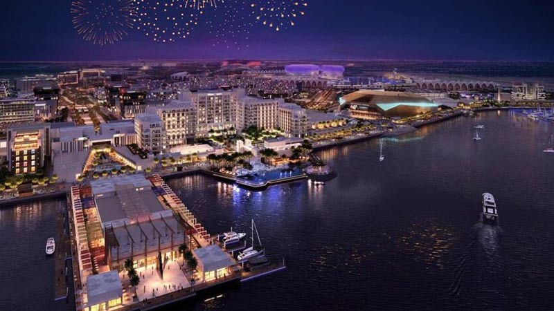 yas-bay-waterfront-at-night-with-fireworks-and-buildings-lit-up