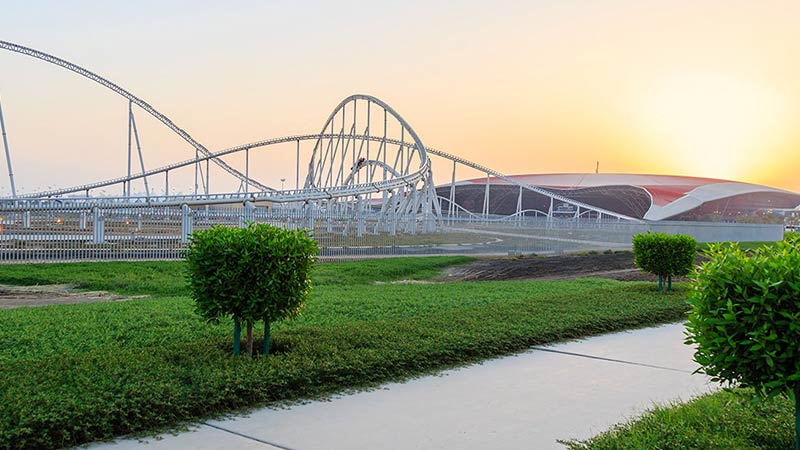 views-of-ferrari-world-from-outside-its-gate-with-grasses-and-bushes-surrounding-the-area-in-the-early-evening