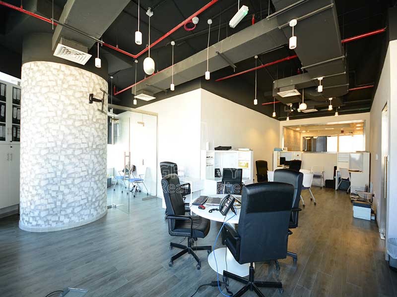 Large-office-area-with-black-color-office-chairs-surrounding-the-table-with-many-lights-hanging-from-the-cieling-in-addax-tower