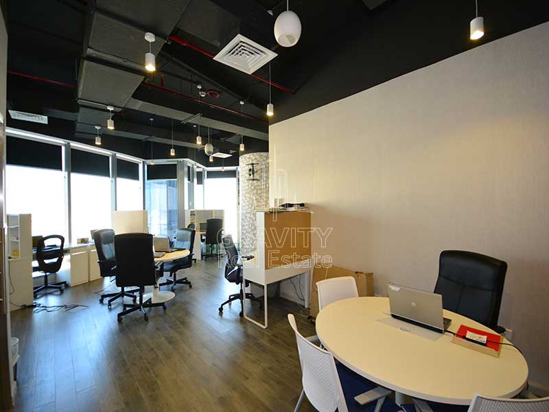 Nice-office-area-with-black-color-office-chairs-and-tables-with-lights-hanging-from-the-cieling-in-addax-tower