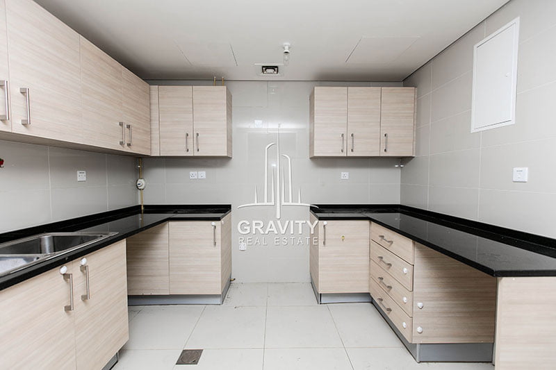 Spacious-kitchen-with modern touch-and-finishing-light-colored-cabinets-white-ceramic-tiles-in-1-bedroom-apartment-ocean-terrace-reem-island