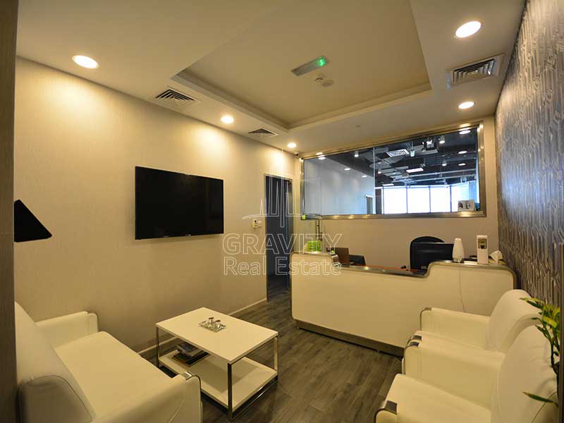 a-beautiful-looking-reception-area-with-white-colored-sofa-and-coffee-table-and-wall-with-mounted-television-in-Addax-Tower