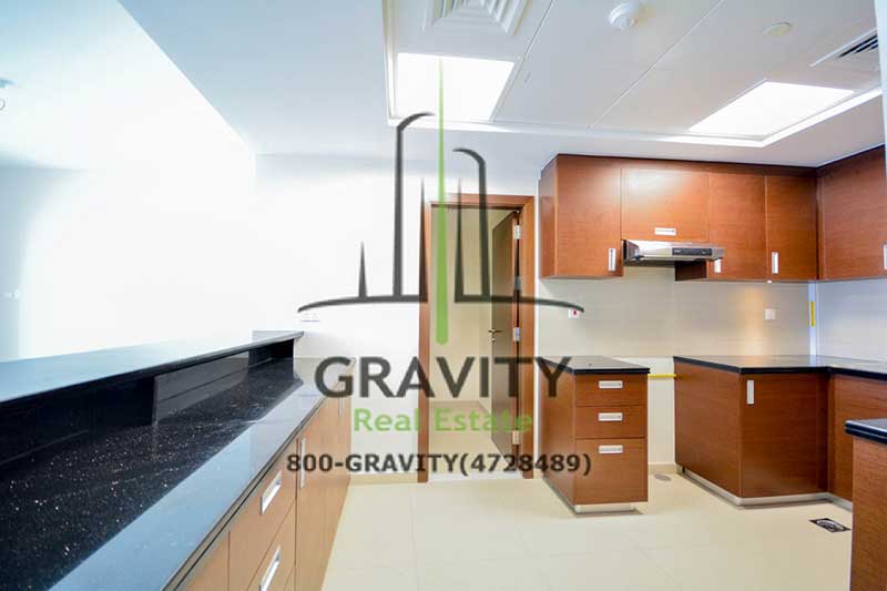 amazing-kitchen-w-brown-cabinets-and-black-marble-counter-top-in-a-2-br-apt-in-arc-tower-reem-island