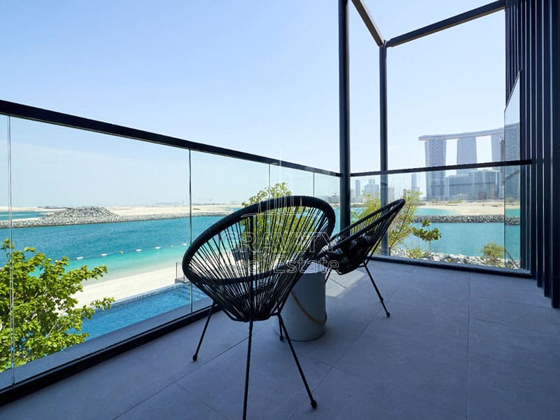 nice-balcony-with-a-black-chair-and-white-table-overlooking-a-body-of-water-in-pixels-abu-dhabi