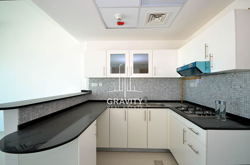 open-kitchen-black-marbled-counter-top-white-cabinets-in-reem-island-2-bedroom-marina-bay-by-damac