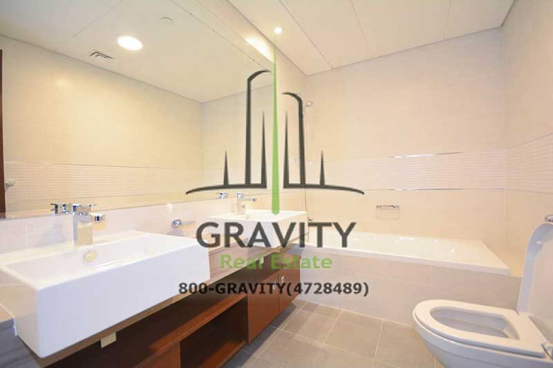 well-maintained-bathroom-with-bathtub-toilet-sink-and-huge-vanity-mirror-on-wall-in-a-2-bedroom-apar