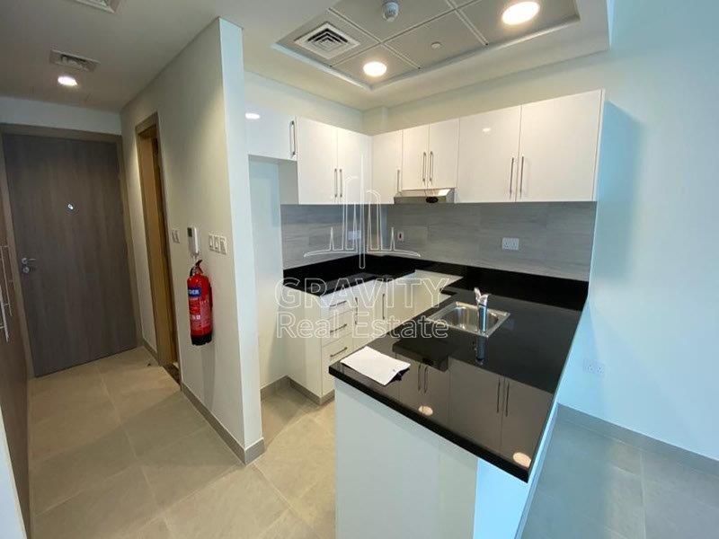 amazing-open-kitchen-wtih-white-cupboards-and-black-marble-on-top--in-soho-square-apartments