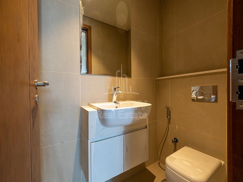 bathroom-with-white-sink-and-toilet-and-mirrors-2-bedroom-apartment-in-julphar-tower-residence