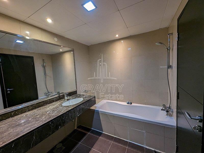 big-washroom-with-nice-white-bath-tub-and-big-mirror-attached-with-sink-in-sun-towers