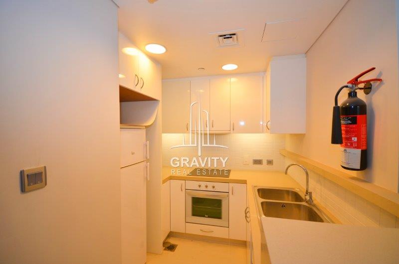 clean-and-modern-kitchen-with-white-cabinets-cupboards-in-a-2-bedroom-apartment-for-sale-in-al-rahba-2