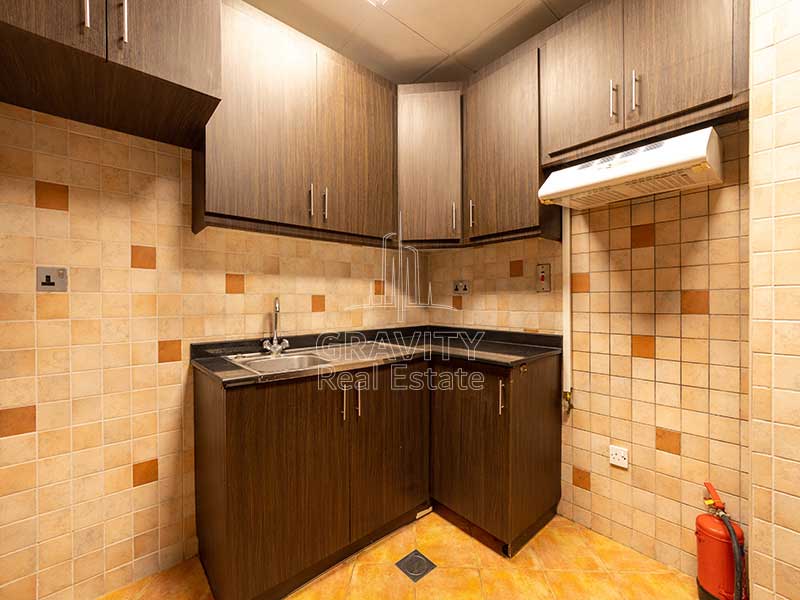 closed-kitchen-with-datk-brown-cabinets-and-orange-floor-in-2-bedroom-apartment-in-hydra-c6