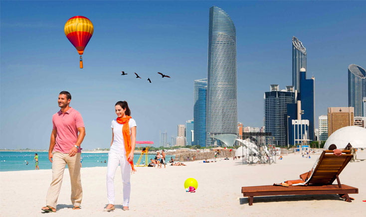 abu-dhabi-beach-with-couple-walking-and-hot-air-balloon-in-the-distance