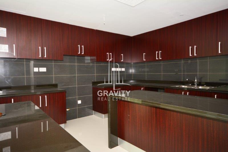 huge-modern-kitchen-with-wooden-touched-cupboards-and-table-in-mag-5-reem-island