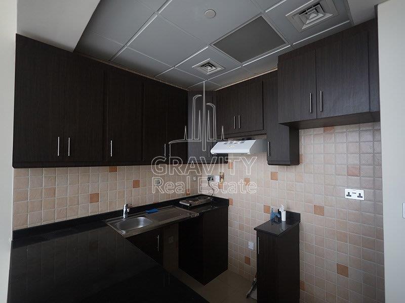 kitchen-of-studio-apartment-in-hydra-c6-tower-with-dark-brown-cabinets