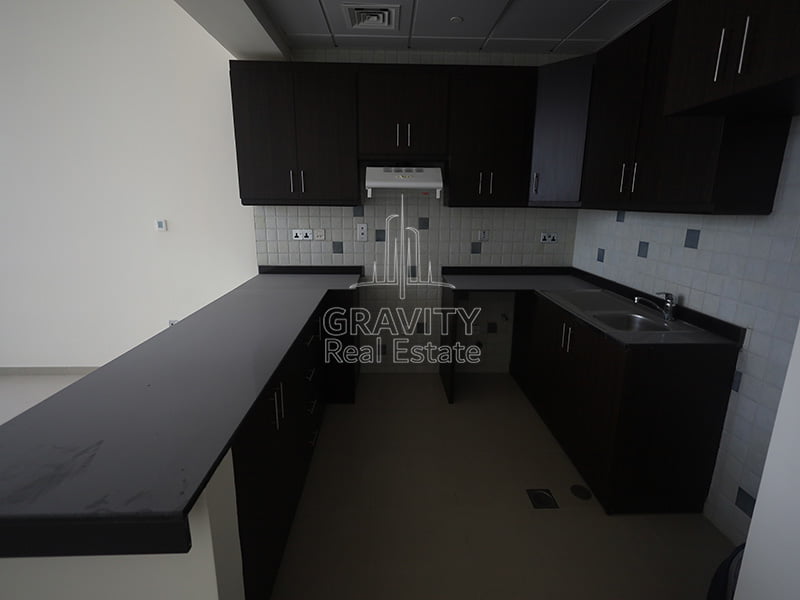 kitchen-of-studio-apartment-in-hydra-tower-c6-with-dark-brown-cabinets-and-countertop