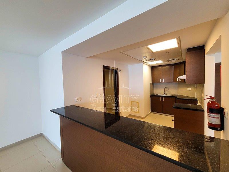 kitchen-w-black-marbled-countertop-brown-cabinets-and-cupboards-in-gate-towers-reem-island