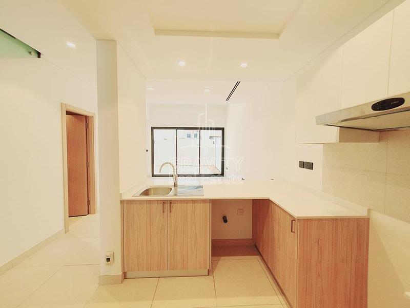 kitchen-with-brown-cabinets--ina-a-2-bedroom-townhouse-in-bloom-garden-abu-dhabi-for-rent