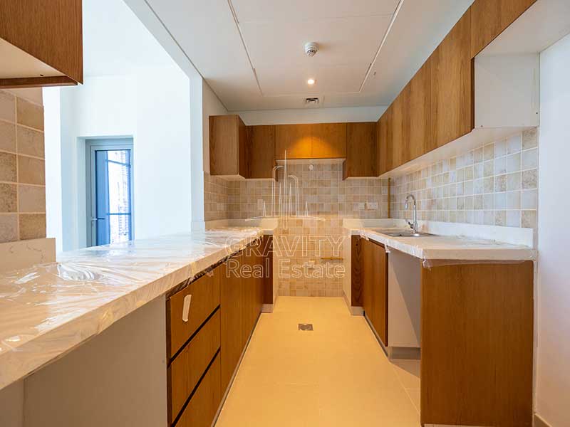 kitchen-with-dark-brown-cabinets-and-sink-in-3-bedroom-apartment-in-julphar-residence-al-reem-island